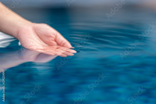 Closeup image of a hand soaking into clear water © Farknot Architect