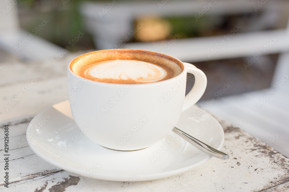 A cup of a coffee in white glass on white table A cup of a coffee in white glass on white table