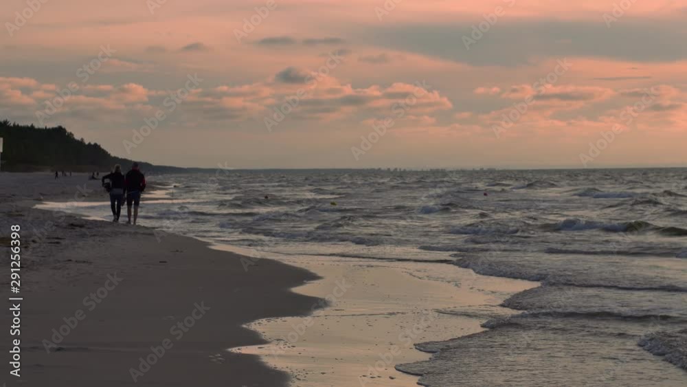 People relaxing on the beach of Baltic Sea at sunset. People relaxing on the beach of Baltic Sea at sunset.