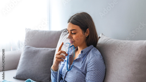 Woman makes inhalation nebulizer at home. Holding a mask nebulizer inhaling fumes spray the medication into your lungs sick patient. Self-treatment of the respiratory tract using inhalation nebulizer photo