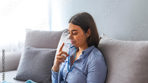 Woman makes inhalation nebulizer at home. Holding a mask nebulizer inhaling fumes spray the medication into your lungs sick patient. Self-treatment of the respiratory tract using inhalation nebulizer