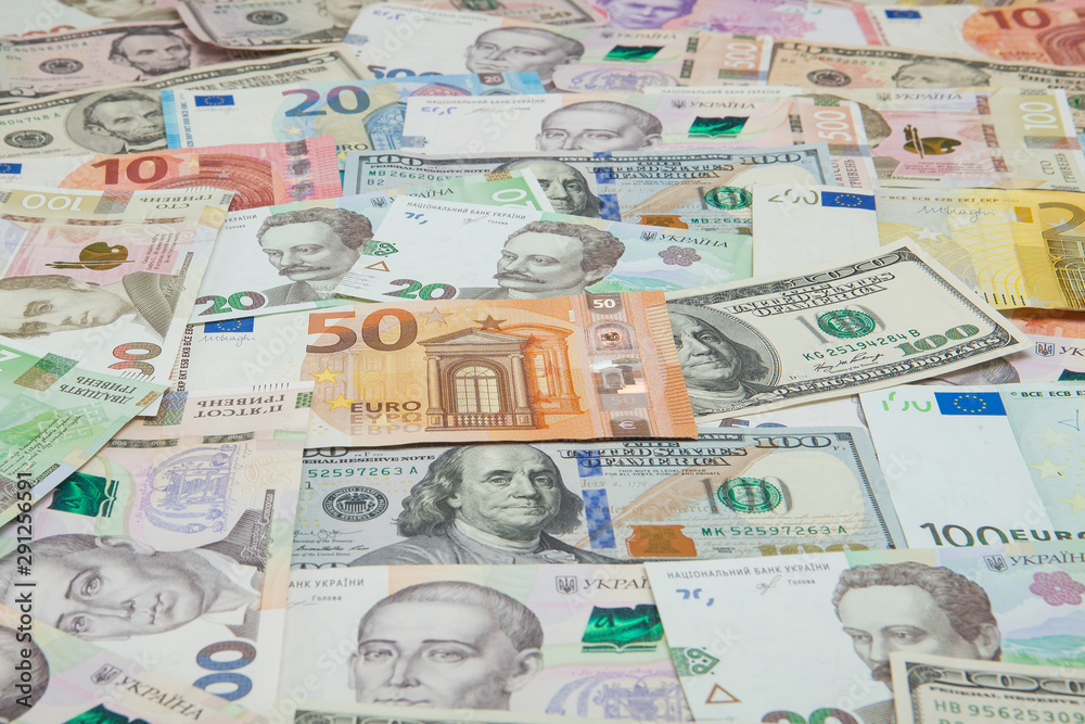 Obraz premium Money and finances concept. One hundred dollar new bill on colorful abstract background of Ukrainian, American and euro national currency banknotes