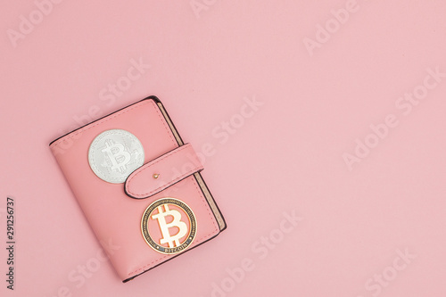 Bitcoins on a pink wallet on the pink background with copy space photo