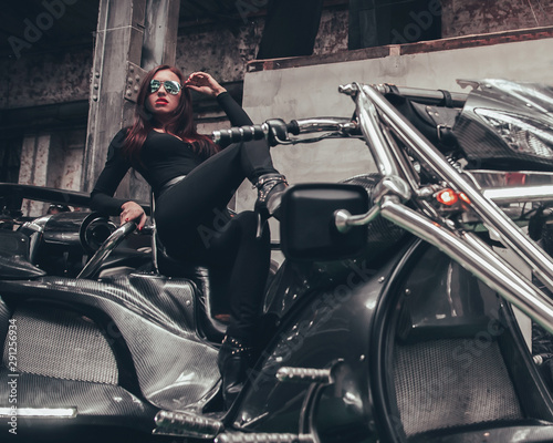 fashionable young woman posing sitting on new trike photo