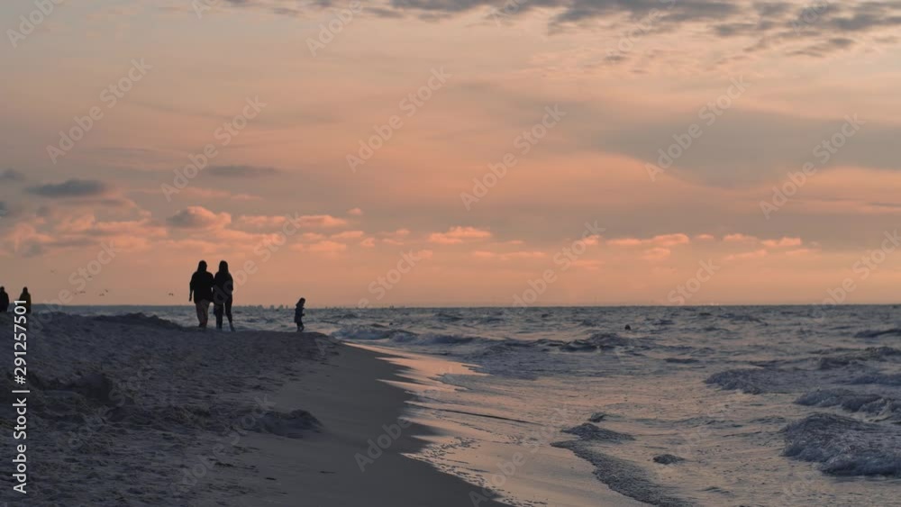 People relaxing on the beach of Baltic Sea at sunset. People relaxing on the beach of Baltic Sea at sunset.