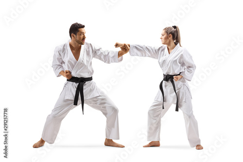 Man and woman with black belts in karate fighting