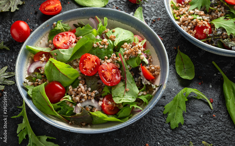 Buckwheat salad with cherry tomatoes, red onion and green vegetables. Healthy diet food