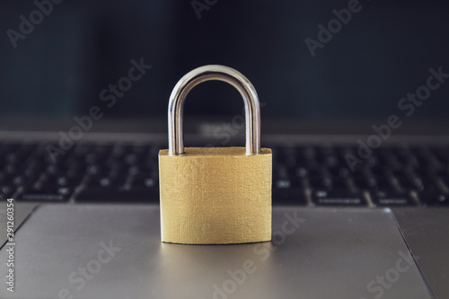 Computer security concept with a closed golden  padlock on top of the keyboard
