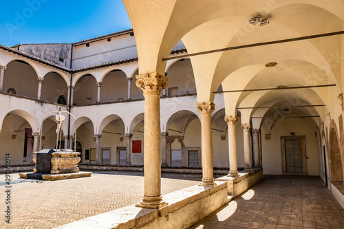 The cloister of the Romanesque church of San Francesco, in the city of Amelia, in Umbria. The well in the center, surrounded by the portico with archways and columns. photo