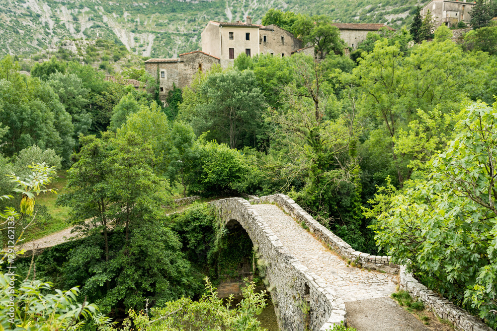 An old stone bridge spans the River Vis near the village of Navacelles