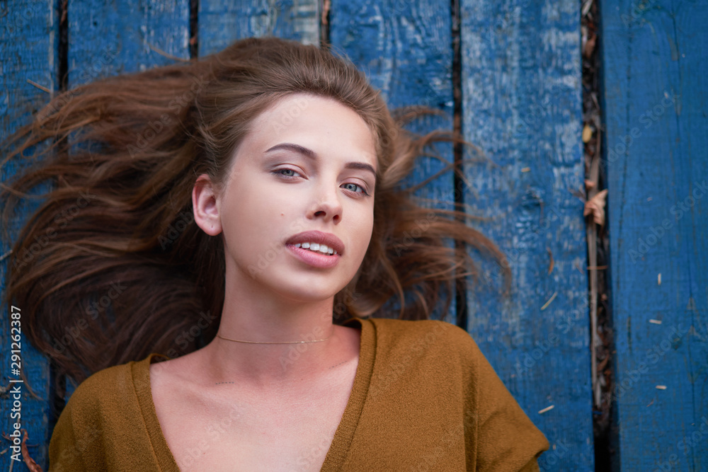 Fototapeta premium Beautiful caucasian young woman Lying on her back on wooden background.