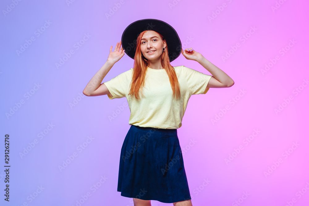 Redhead girl in hat touches on a colored background Redhead girl in hat touches on a colored background