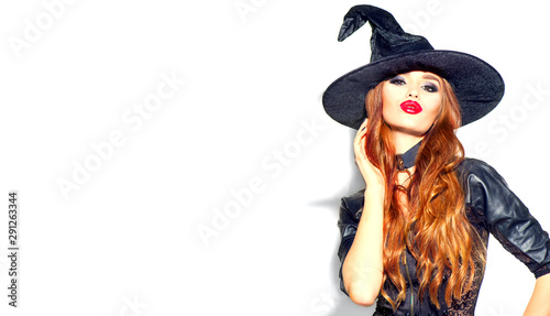 Halloween Sexy Girl wearing witch costume with a hat. Party, Celebrating. Beauty Woman with long red hair and holiday bright make-up isolated on white background. Leather dress