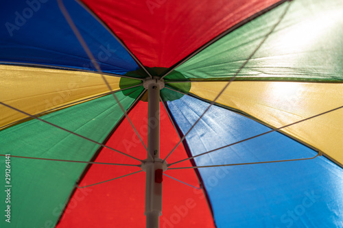 multicolored umbrella open to the sun. Bottom view on the inside