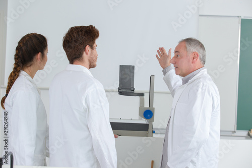 mature male professor in front of students in classroom