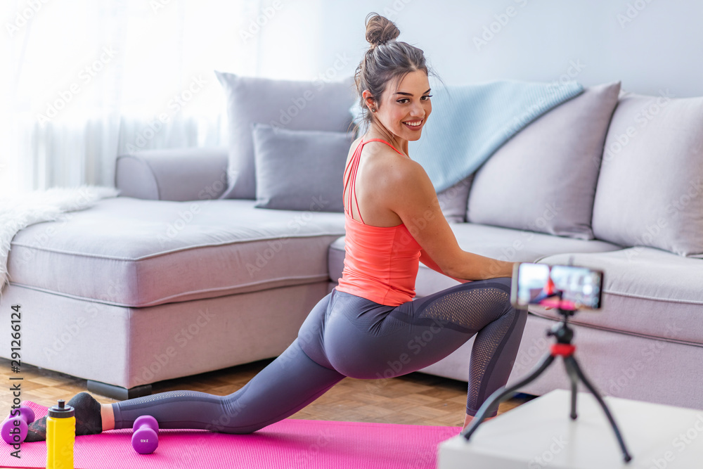 Obraz premium Young woman doing fitness exercises at home