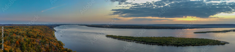 Aerial panoramic landscape, view on Volga river with small sand islands and colorful green, orange and yellow forest during autumn evening, Samara, Russia 