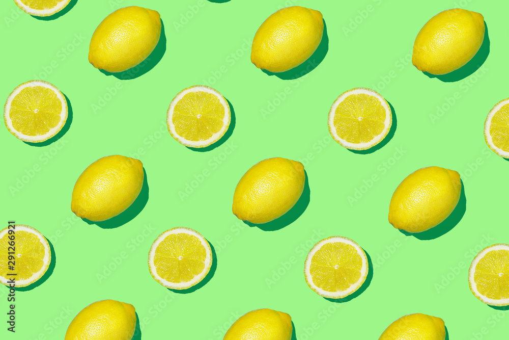 Colorful fruit pattern of fresh lemon and lemon slices on colored background. Lemon slices top view, flat lay
