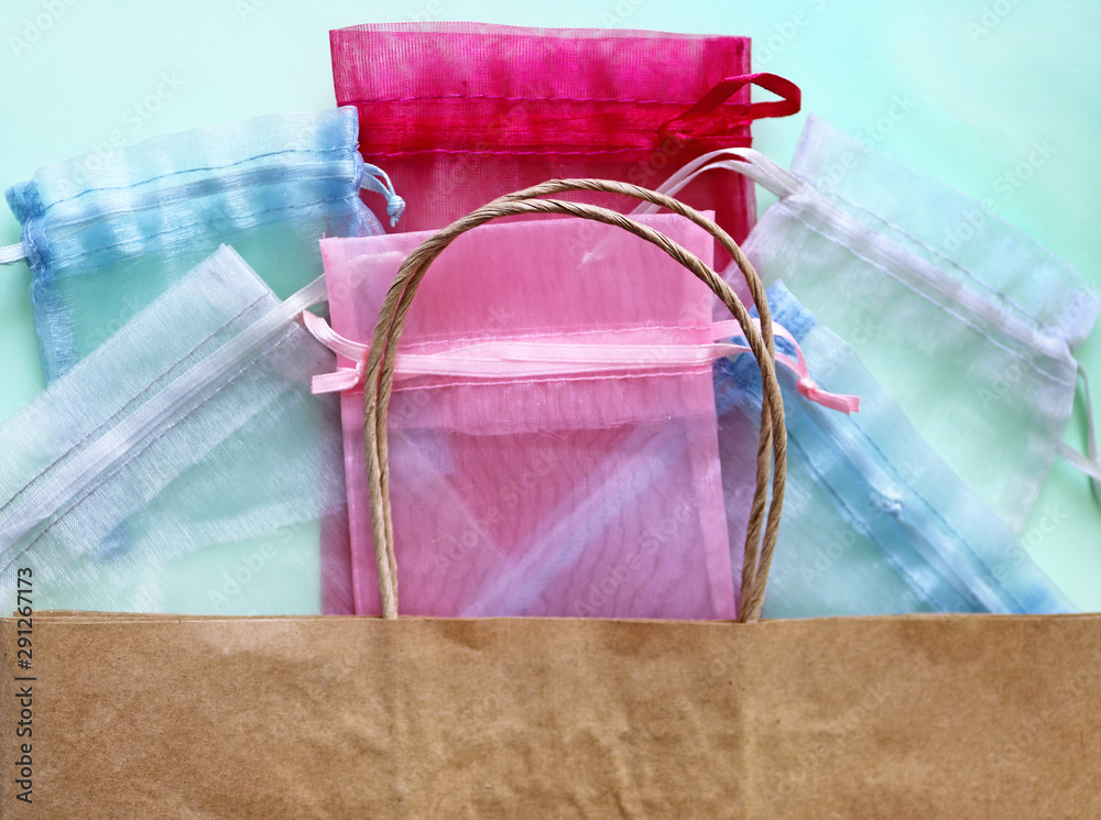 Organza bags and recycled eco bag on blue background. Organza bags