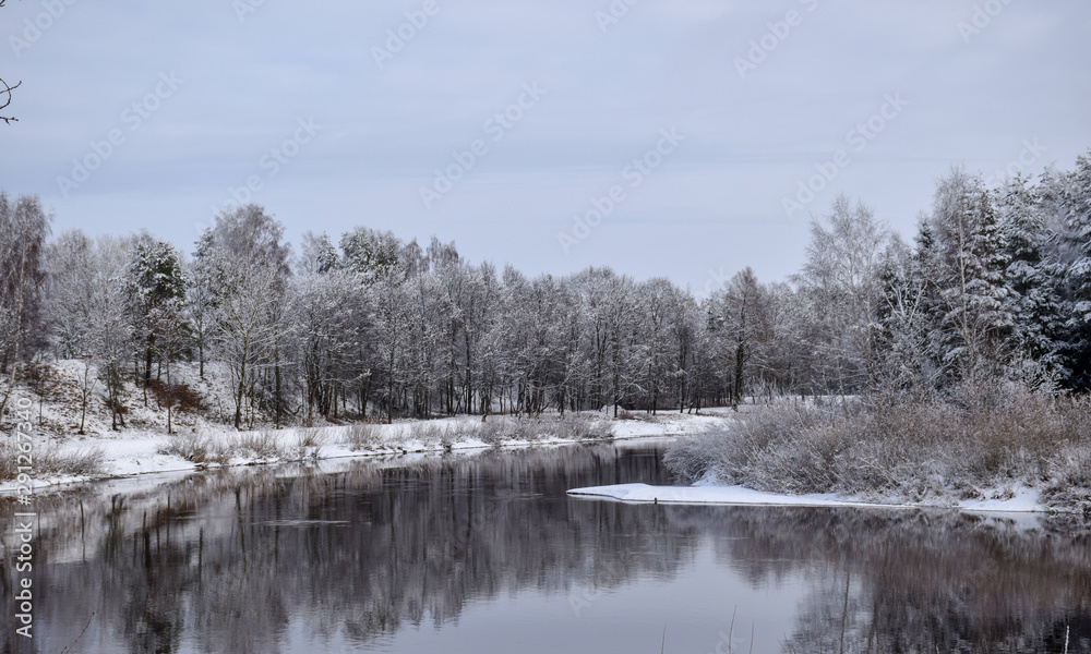 view of beautiful river winter day, snowy trees, many clouds, beautiful reflections, calm river water, Gauja river, Valmiera, Latvia view of beautiful river winter day, snowy trees, many clouds, beautiful reflections, calm river water, Gauja river, Valmiera, Latvia