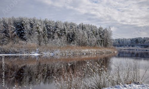 view of beautiful river winter day, snowy trees, many clouds, beautiful reflections, calm river water, Gauja river, Valmiera, Latvia © ANDA