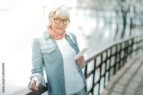 Smiling dame in glasses standing in headsets near the bridge