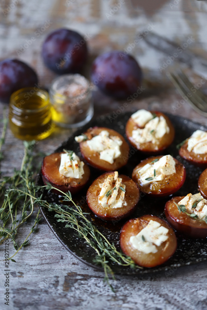 Baked plums with feta cheese. Autumn food. Keto diet. Selective focus. Macro. Baked plums with feta cheese. Autumn food. Keto diet. Selective focus. Macro.