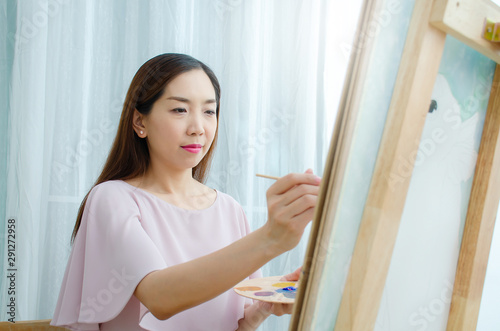 Woman female artist painting picture on canvas with oil paints at my home as her hobby.