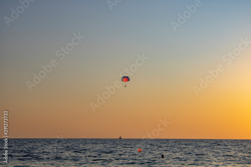 Parachuting over the sea in the evening is especially pleasant