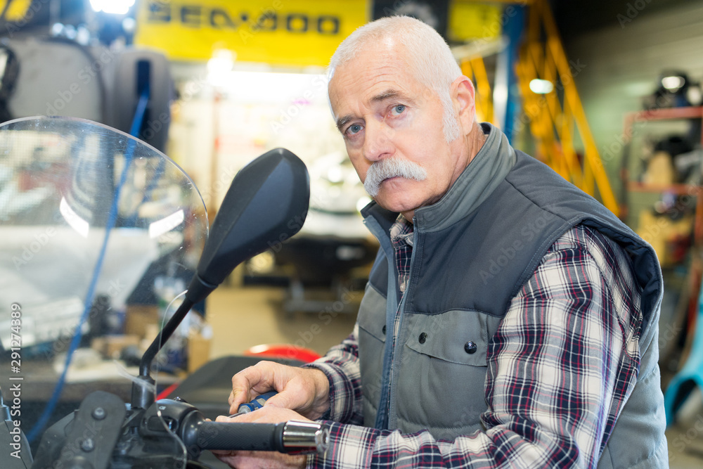 senior man repairing damaged motorcycle engine senior man repairing damaged motorcycle engine