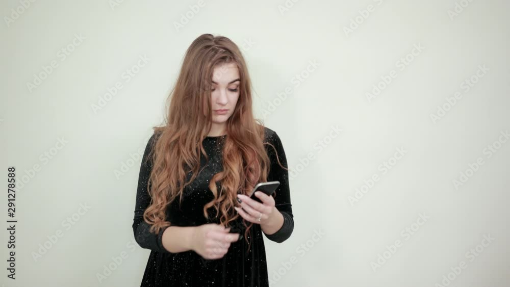 girl brown haired in black dress over isolated white background shows emotions girl brown haired in black dress over isolated white background shows emotions