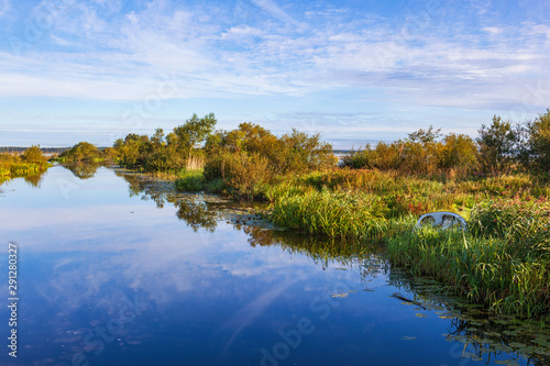 Lakeshore on the late summer with water reflections