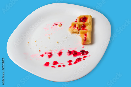 Belgian waffle with raspberry jam on a blue background. copy space