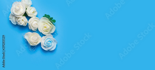 artificial flowers on a blue background frame for text. copy space