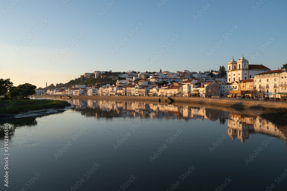 View of Alcacer do Sal cityscape from the other side of the Sado river at sunset