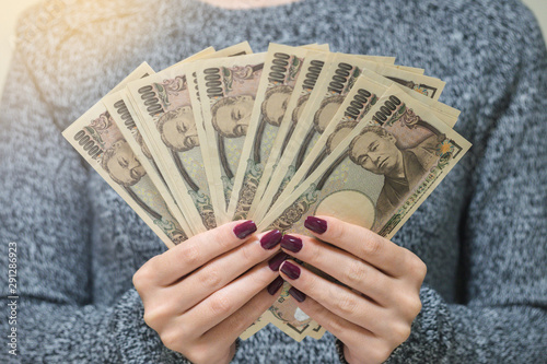 Hands holding a lot of japanese money. ready to shopping