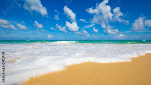 Sea wave on summer white beach with cloud sky