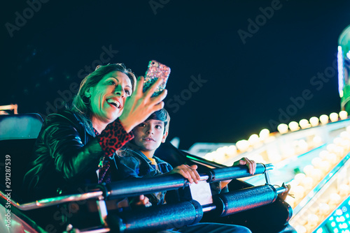 mother and son at the carnival using smart phone 
