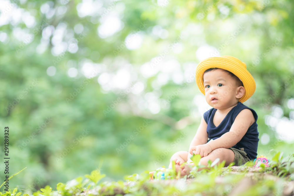 Kid boy with yellow hat travel in green city park Kid boy with yellow hat travel in green city park