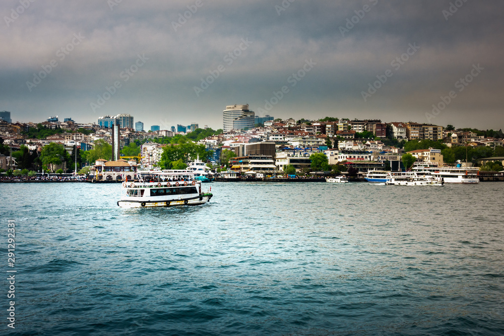 Fototapeta premium Ferry on sea with cityscape in background
