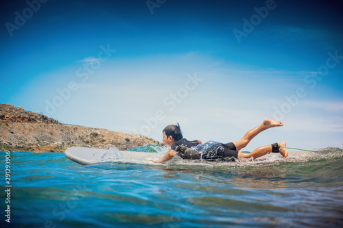 Little boy on top of the body board riding on the sea wave, Greece
