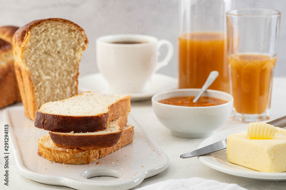 Freshly brioche bread and butter, juice and jam. Continental breakfast.