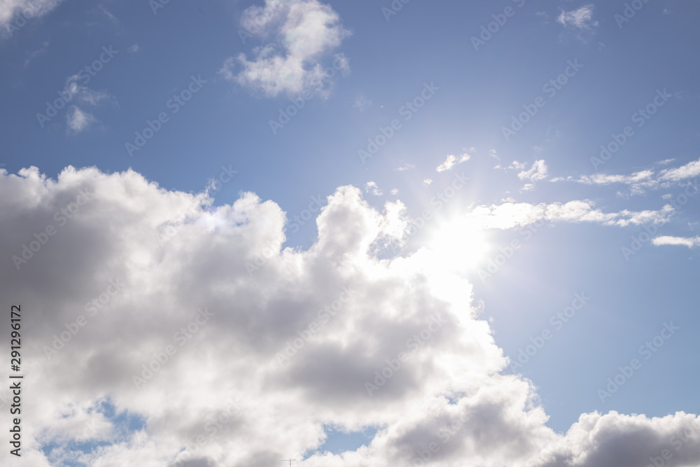 blue sky and sun shine through white clouds