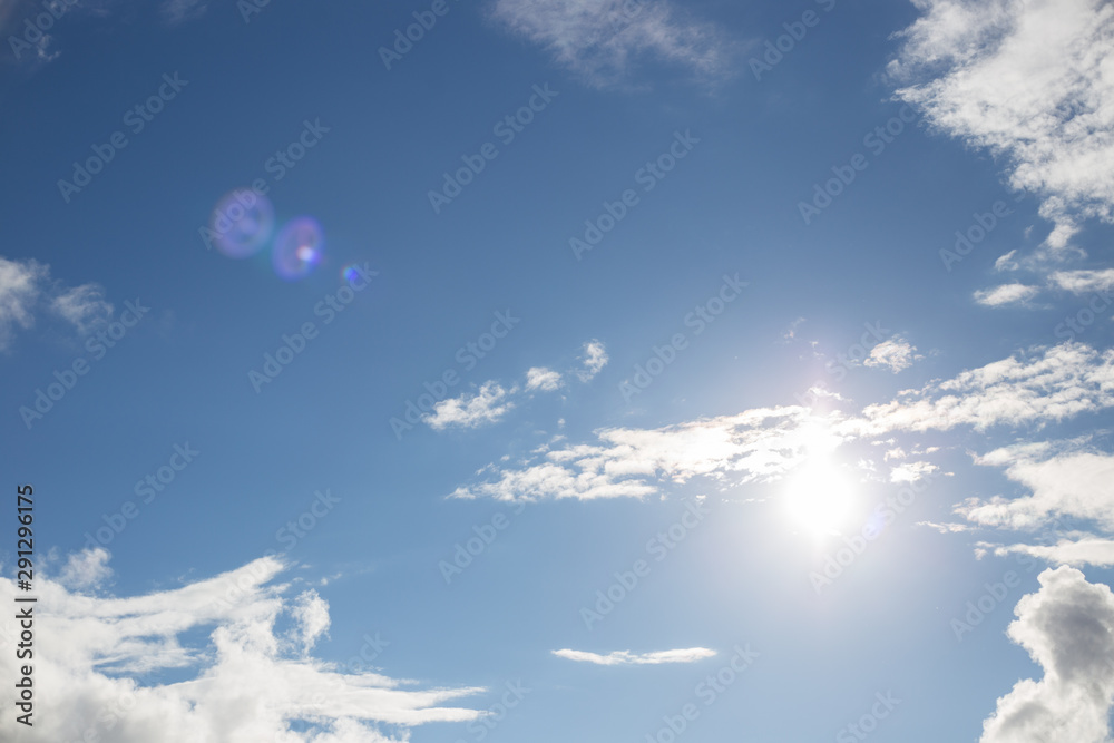 blue sky with white clouds and glowing sun blue sky with white clouds and glowing sun