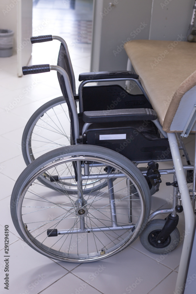 a medical office in which there is a wheelchair near the chair for transporting people with motor disabilities and the disabled