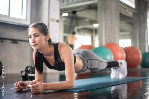 Full Length Of Determined Woman Exercising In Plank Position At Gym © ic36006