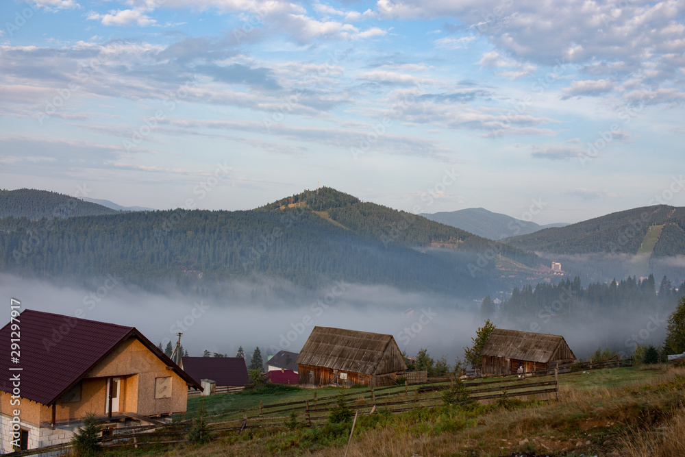 Early foggy morning in the mountains. Carpathians, Bukovel, lawn houses.