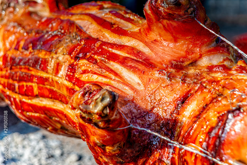 Suckling pig turns over the open fire