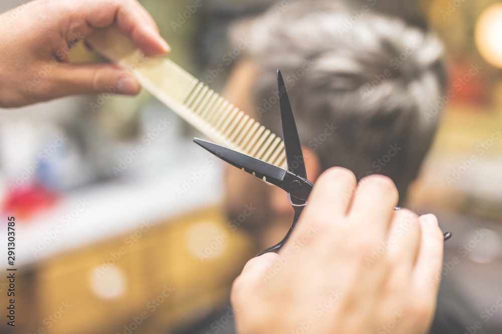 Barber cutting and modeling hair with scissors and comb. Barber cutting and modeling hair with scissors and comb.