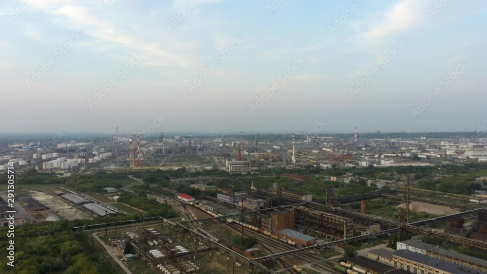 Aerial view from above on old rusty abandoned cooling towers of electric plant station and city panorama, industrial district in Samara region, Russia Aerial view from above on old rusty abandoned cooling towers of electric plant station and city panorama, industrial district in Samara region, Russia